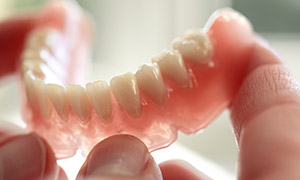 Person holding a removable denture.