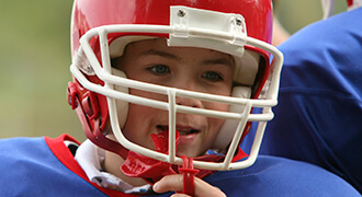 Child with mouthguard playing football