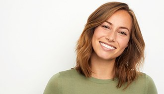 Smiling woman in a green shirt in front of a white background