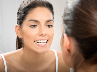 Woman looking at her perfect smile in mirror
