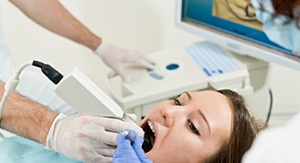 A dentist using a CAD/CAM digital impression system to capture images of a patient’s tooth