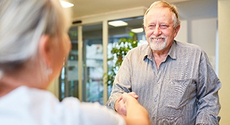 Employee explaining cost of dentures in Tyler to patient