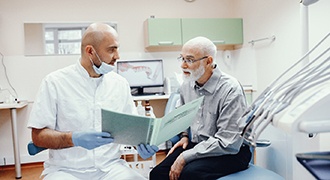 Dentist explaining cost of dentures in Tyler to patient