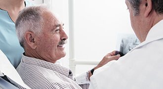 Smiling patient speaking with Tyler dentist