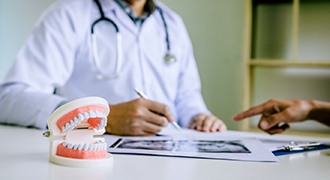dentist calculating cost of dental implants