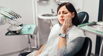 Woman with toothache at dentist's office 