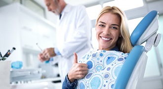 woman giving thumbs up in dental chair 