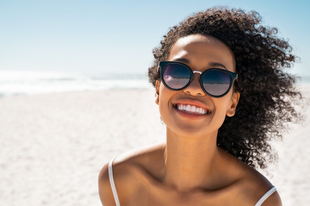 person on summer vacation smiling on a beach