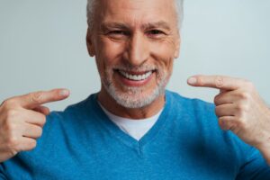 Senior man showing off dentures. 